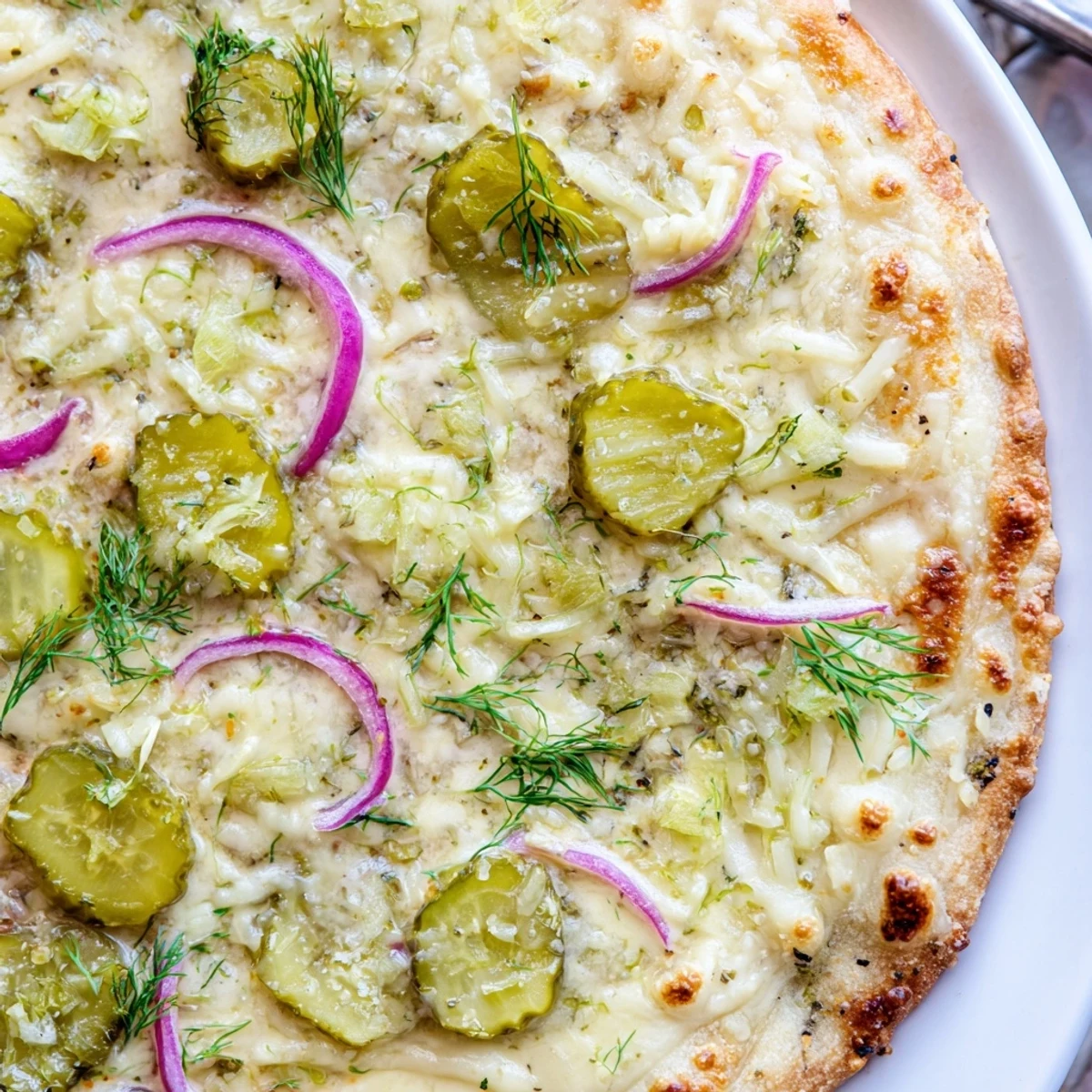 Tangy Pickle Pizza topped with creamy sauce and crispy dill pickles.  