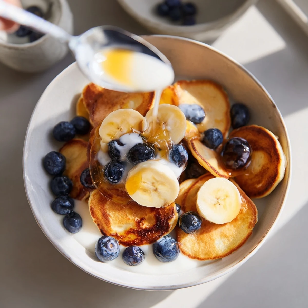 Delightful mini pancake cereal, crispy outside and fluffy inside, served with milk.  