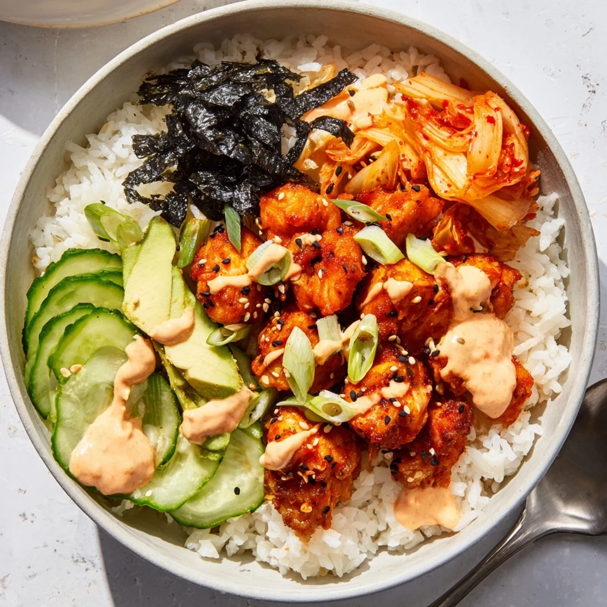 Crispy Salmon Rice Bowl topped with spicy mayo, avocado, and tangy kimchi.