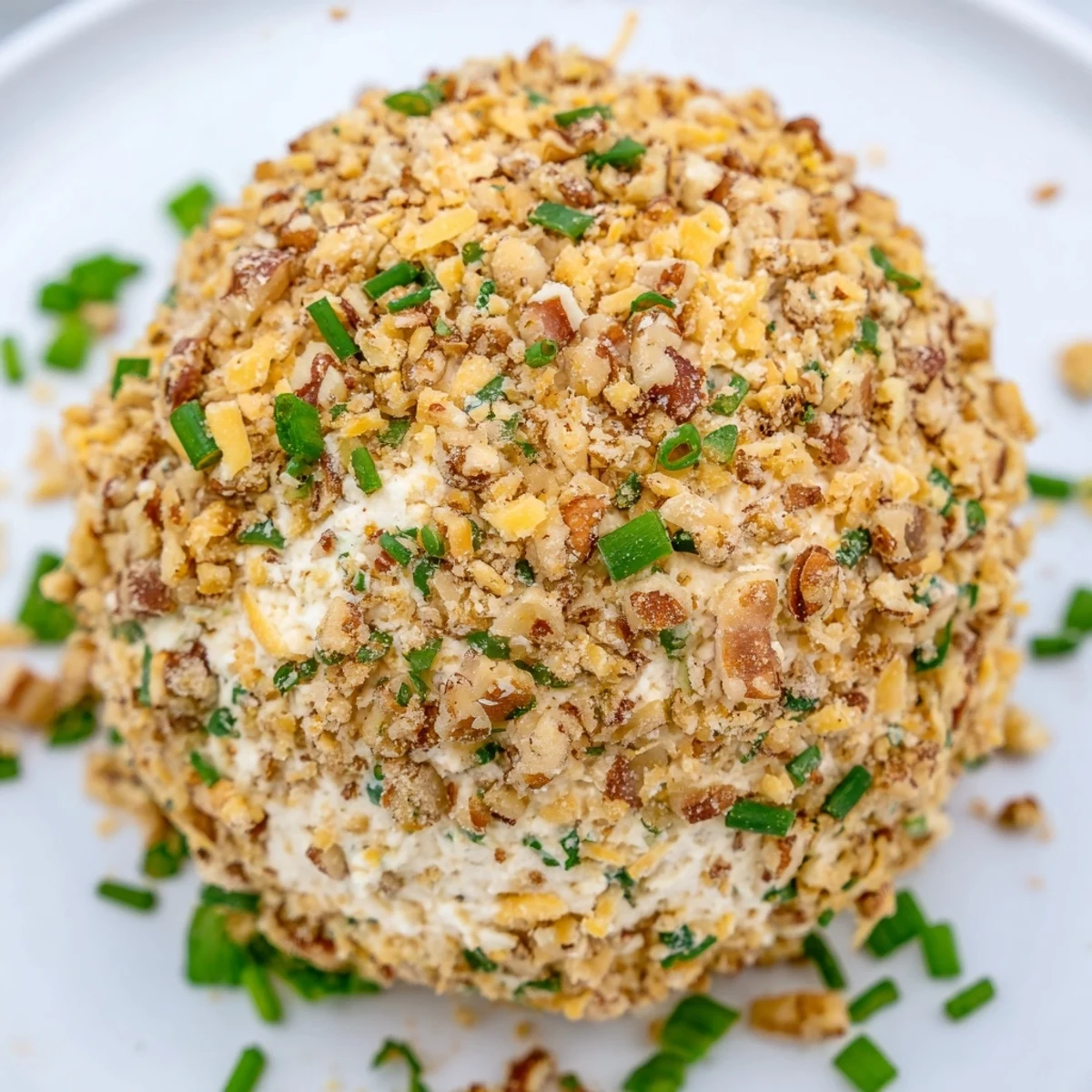 A vibrant cheese ball with ranch seasoning, coated in crunchy pecans, ready for dipping.