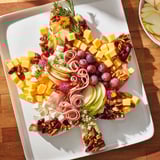 Vibrant Maple Leaf Grazing Tray, perfect for fall, featuring colorful cheeses and crackers.