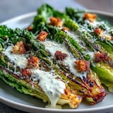 Smoky grilled romaine hearts topped with croutons and Parmesan for a delightful salad.