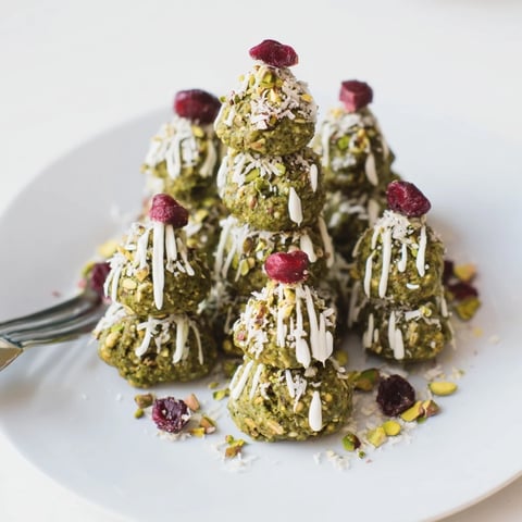 Vibrant green Matcha Pistachio Christmas Tree Energy Bites, drizzled with white chocolate and ready for holiday snacking.