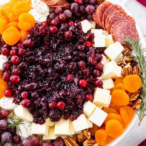 Vibrant cranberry wreath platter featuring homemade cranberry sauce and creamy cheeses ready to serve.