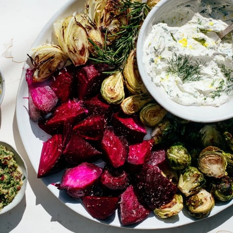 A gorgeous Pine Forest Winter Mezze Board, filled with roasted veggies and vibrant garnishes, invites you in.
