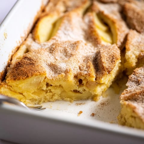 Freshly baked Baked Apple Cake with tender apple slices and a warm cinnamon sugar topping on a rustic wooden table.
