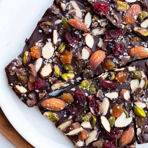 Homemade chocolate bark pieces glistens; a sweet, salty afternoon treat or gift.