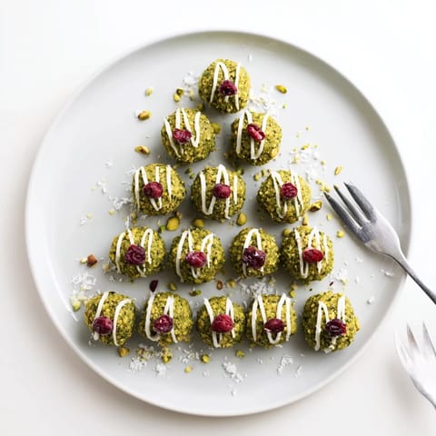 Close-up of Matcha Pistachio Christmas Tree Energy Bites, showing festive holiday shapes with scattered cranberries.