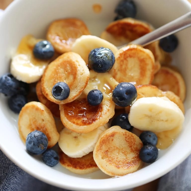 Mini pancake cereal arranged in a bowl, perfect for a fun morning treat.