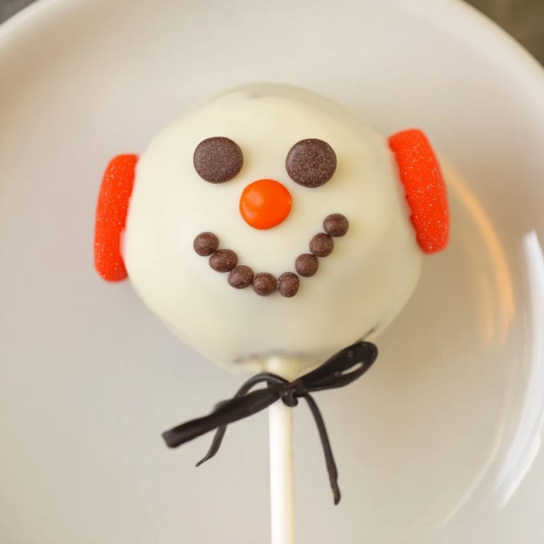 Enjoy a close-up of the easy-to-make Budget-Friendly Oreo Snowman Pops, a delightful no-bake treat.