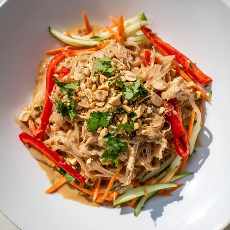 Creamy peanut dressing coats this Thai-Inspired Peanut Chicken Pasta, topped with fresh cilantro and crunchy peanuts.