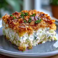 Lightened-Up Funeral Potatoes with Greek Yogurt Sauce in a golden, crispy-cornflake-topped casserole dish, perfect for potlucks.